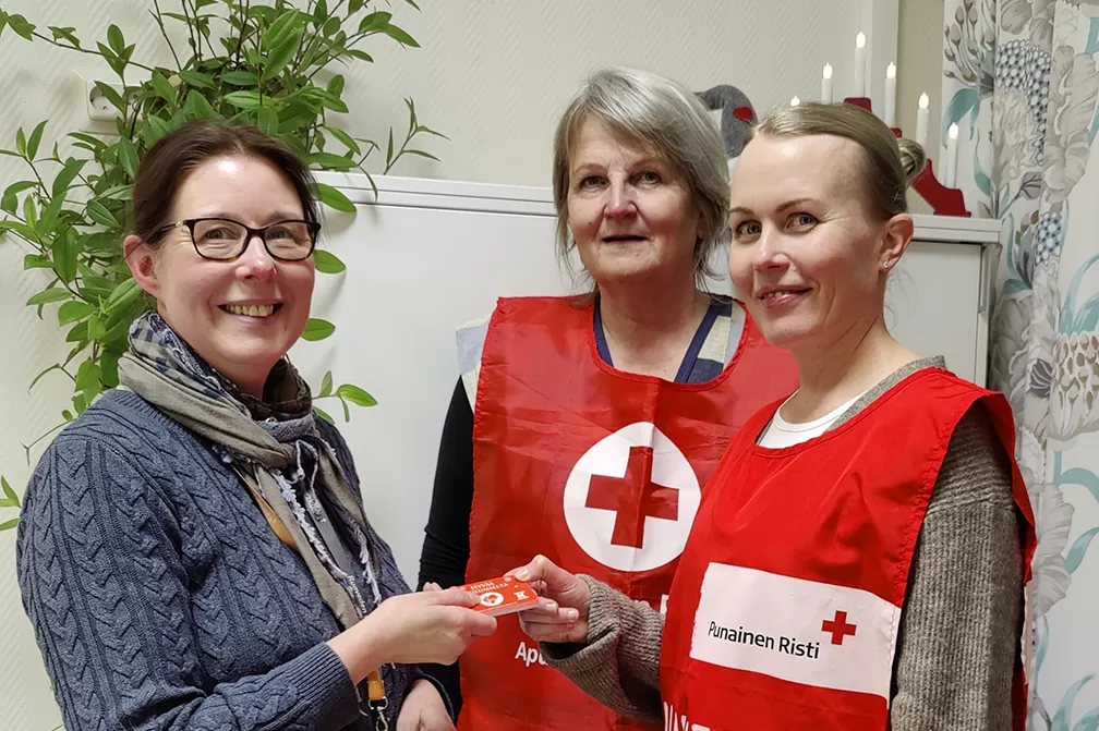	Erja Lempinen ottaa vastaan SPR:n Marita Heikkilän ja Päivi Kaitalan tuoman keräyslahjoituksen.